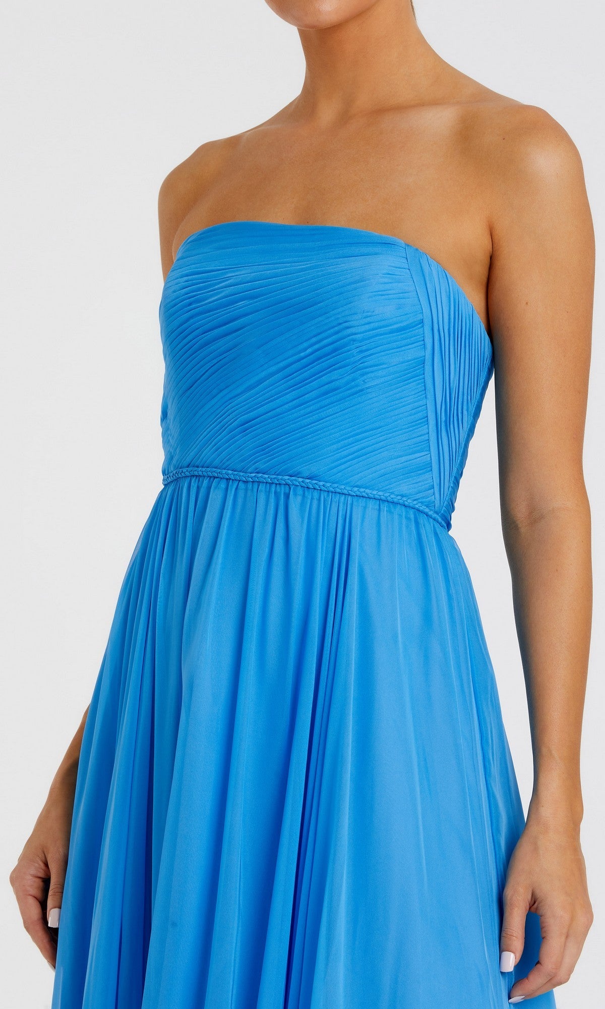A woman wearing the Mac Duggal 68847 Long Formal Dress—a bright blue, strapless chiffon gown with a fitted bodice and flowing, pleated A-line skirt—photographed from shoulders to knees.